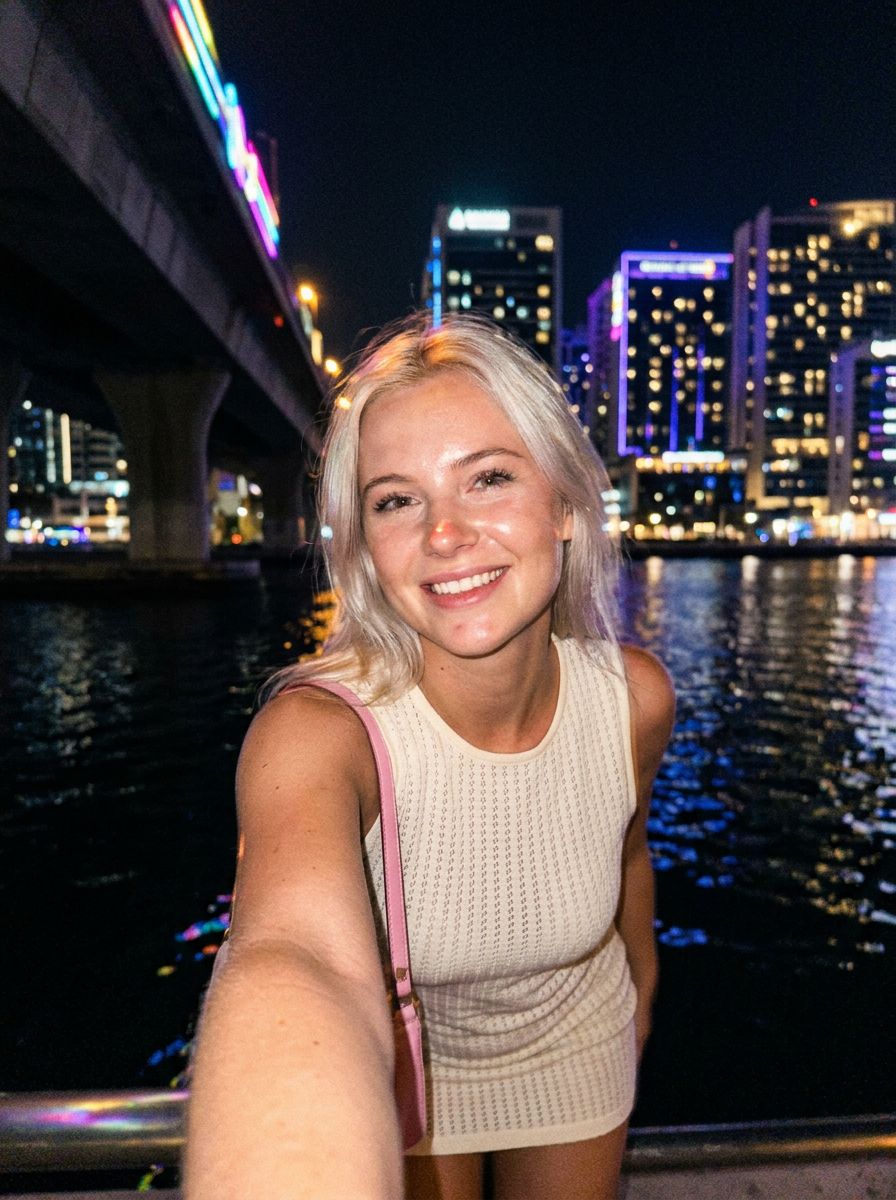 Gen NanoBanana AI image model comparison — NanoBanana 2 output: nighttime waterfront portrait selfie, warm smile, natural skin texture, fine hair strands against dark sky